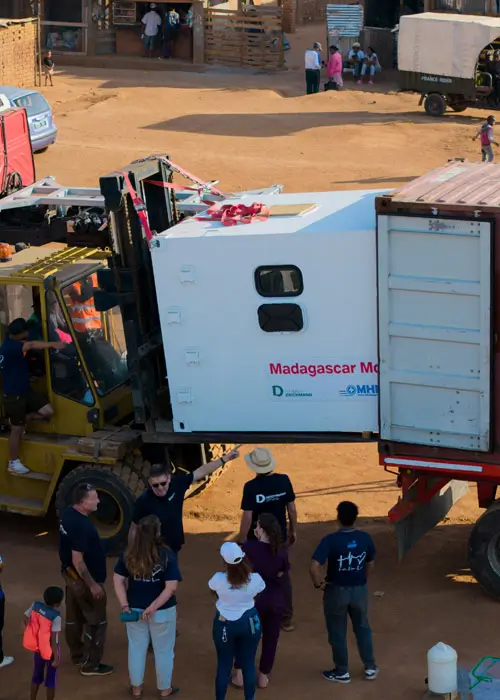 DEICHMANN-Stiftung | Madagascar Mobile Clinic – ein Shelter der Madagascar Mobile Clinic wird aus dem Überseecontainer entladen – Gesundheitsangebote in ländliche Regionen Madagaskars bringen Madagascar Mobile Clinic – ein Gabelstapler hebt eine mehrere Kubikmeter große Box aus einem Überseecontainer