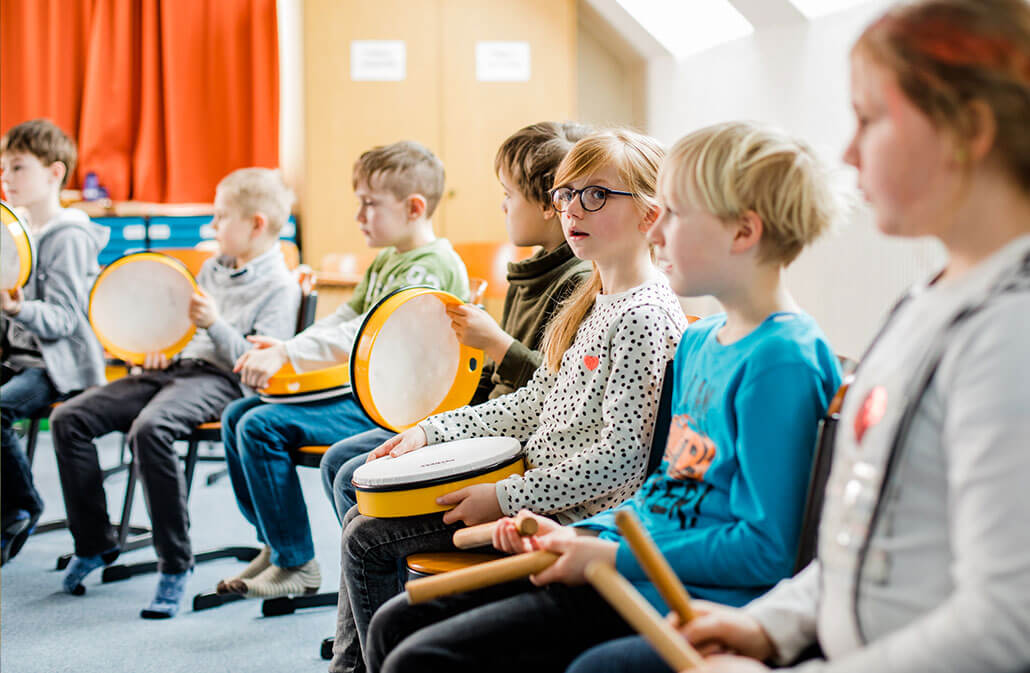deichmann-stiftung-projekt-Kunst-Kultur-jekits Grundschulkinder musizieren mit Tambourins und Klanghölzern